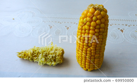 Homemade golden sweet corn cob ready to eat on the white table. Boiled yellow sweet corn cobs on white background Homemade golden sweet corn cob ready to eat on the white table. Boiled yellow sweet corn cobs on white background 69950800