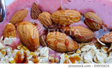 Vegan smoothie bowls with coconut flakes, chia seeds, almond and granola on pink background. Breakfast bowl with fruit and cereal, close-up, top view, healthy vegan food 69950828