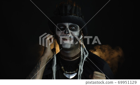 Scary guy in costume of Halloween skeleton wearing earphones, listening music, dancing, celebrating Scary guy in costume of Halloween skeleton wearing earphones, listening music, dancing, celebrating 69951129