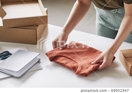 Woman packing new shirt Woman packing new shirt 69952847