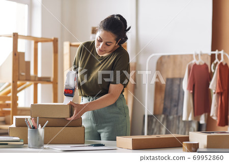 Woman packing boxes Woman packing boxes 69952860