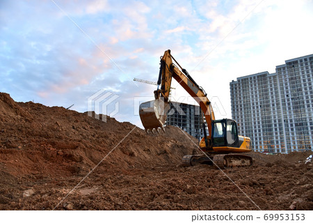 Excavator during earthmoving at construction site Excavator during earthmoving at construction site 69953153