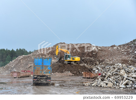 Excavator dig construction waste at landfill. Excavator dig construction waste at landfill. 69953229