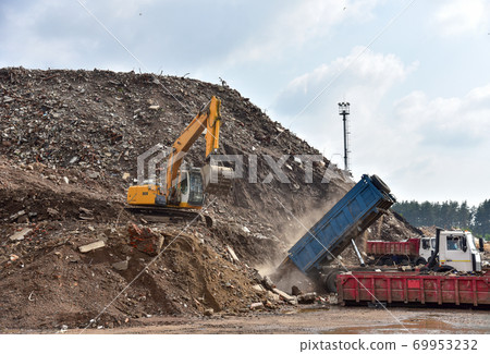 Excavator dig construction waste at landfill. Excavator dig construction waste at landfill. 69953232