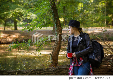 girl with a red mug in the park girl with a red mug in the park 69954073
