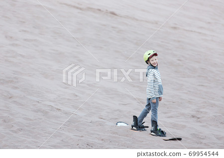kid sandboarding in atacama desert 69954544