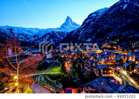 View of old village in twilight time with Matterhorn peak background in Zermatt, Switzerland. View of old village in twilight time with Matterhorn peak background in Zermatt, Switzerland. 69955283