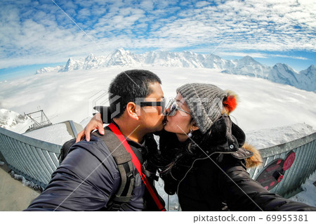 Young Couple Tourists selfie near view of the Swiss Skyline from Schilthorn, Switzerland 69955381