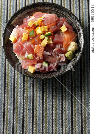 Seafood bowl with tuna and salmon placed on a Japanese-patterned cloth (overhead view) 69956518