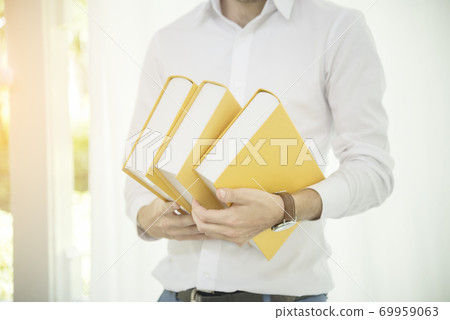 Caucasian man holding text book study hard surprise in content. education concept Caucasian man holding text book study hard surprise in content. education concept 69959063