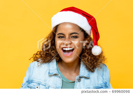 Surprised happy African American woman wearing Christmas hat smiling Surprised happy African American woman wearing Christmas hat smiling 69960098