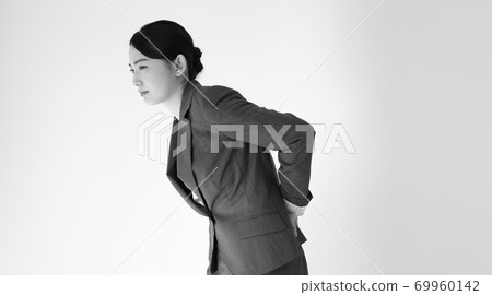 Image of a business woman whose back hurts Image of a business woman whose back hurts 69960142