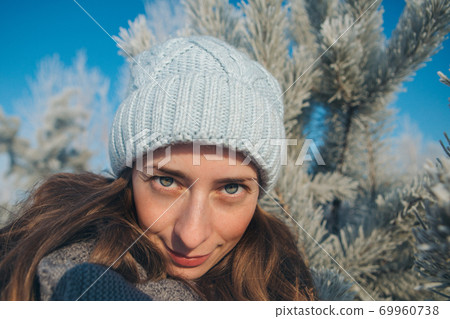 portrait of a beautiful girl in a hat on the background of the snow landscape in the cold season. winter walking. snowy weather portrait of a beautiful girl in a hat on the background of the snow landscape in the cold season. winter walking. snowy weather 69960738