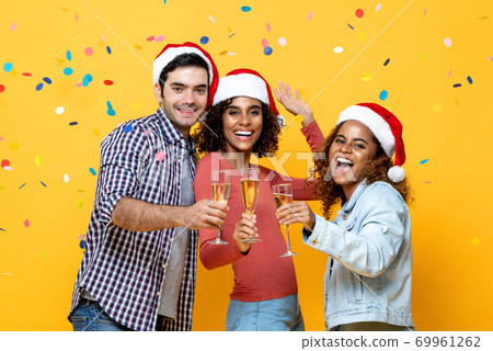 Happy diverse friends celebrating Christmas drinking champagne together Happy diverse friends celebrating Christmas drinking champagne together 69961262