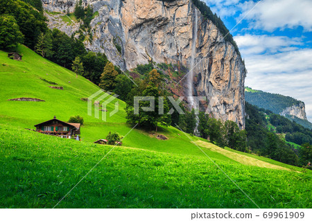 Fabulous Lauterbrunnen alpine village and Staubbach waterfall in background, Switzerland Fabulous Lauterbrunnen alpine village and Staubbach waterfall in background, Switzerland 69961909