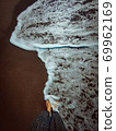 a wave comes in, as I stand and wait. copy space. top down view. 69962169
