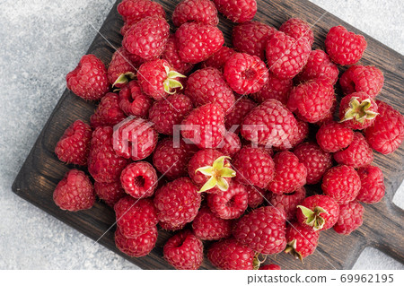 A pile of fresh juicy raspberries on a wooden Board, copy space. 69962195