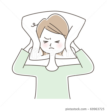 A woman who is frustrated by the noise and closes her ears with a pillow 69963725