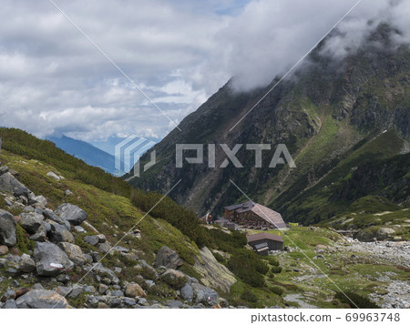 Summer view of Sulzenau mountain hut, Sulzenauhutte with resting tourist people. Alpine in mountain valley in Stubai Austrian Alps 69963748