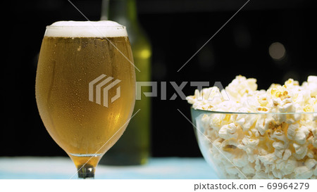 Glass of beer and popcorn 69964279