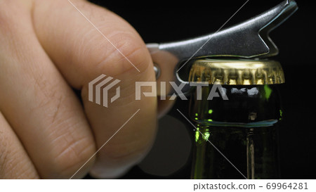 Male hand opening bottle of beer 69964281