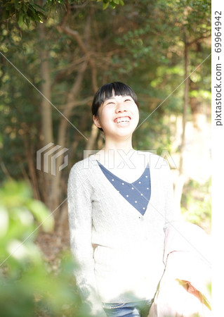一個女孩在公園的新鮮綠色中笑 69964942