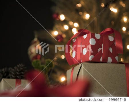 Gift boxes against a bokeh background of christmas lights Gift boxes against a bokeh background of christmas lights 69966746