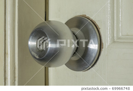 Broken door knob on white wooden door 69966748