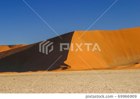 Namib desert dunes dyed in apricot color in the morning sun Namib desert dunes dyed in apricot color in the morning sun 69966909