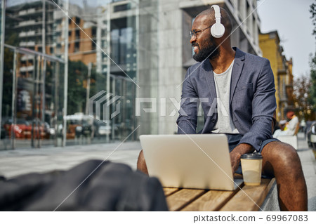 Relaxed international freelancer looking at business center 69967083