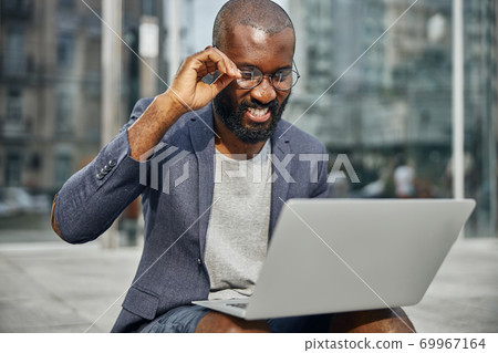 Close up of pleased man that looking at his gadget Close up of pleased man that looking at his gadget 69967164