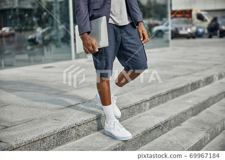 Close up of international man walking downstairs 69967184