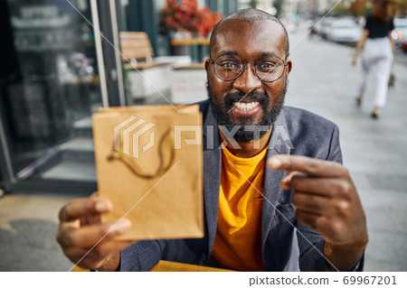 Portrait of cheerful man sitting on the terrace 69967201