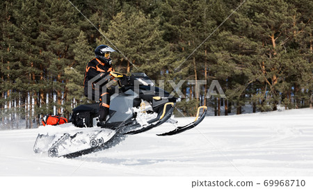 In deep powder snowdrift snowmobile rider driving fast. 69968710