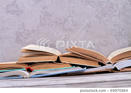 Pile of opened books on gray background. 69970864