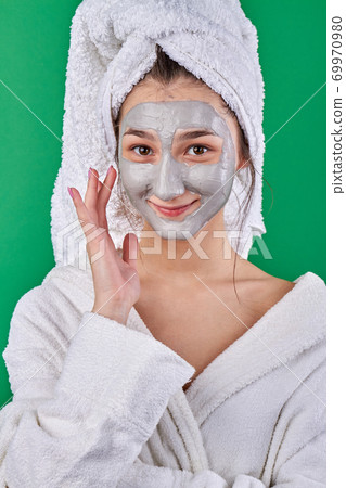Smiling young woman with healing face mask. Smiling young woman with healing face mask. 69970980