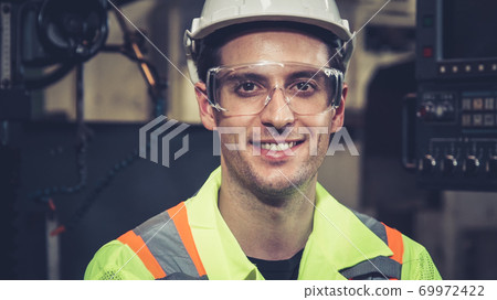 Young factory worker or engineer close up portrait in factory Young factory worker or engineer close up portrait in factory 69972422
