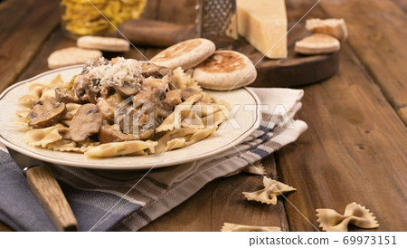 Pasta with mushrooms and tigelle. Butterfly pasta with parmesan and cheese sauce. Typical italian Pasta with mushrooms and tigelle. Butterfly pasta with parmesan and cheese sauce. Typical italian 69973151