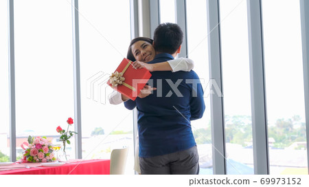 Romantic couple giving gift to lover at restaurant 69973152