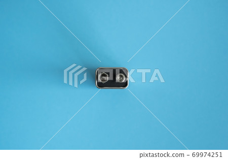 High voltage battery on a blue background. Silver Volt battery. 9V Advanced Lithium Batteries. High voltage battery on a blue background. Silver Volt battery. 9V Advanced Lithium Batteries. 69974251
