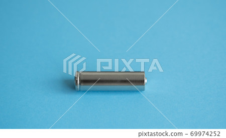 A single rechargeable battery on blue background. Silver alkaline AA battery for different device. Energy. A single rechargeable battery on blue background. Silver alkaline AA battery for different device. Energy. 69974252