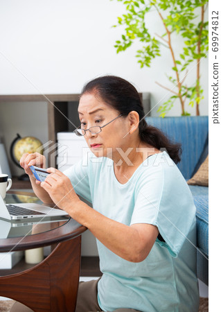 Senior woman looking at the card 69974812