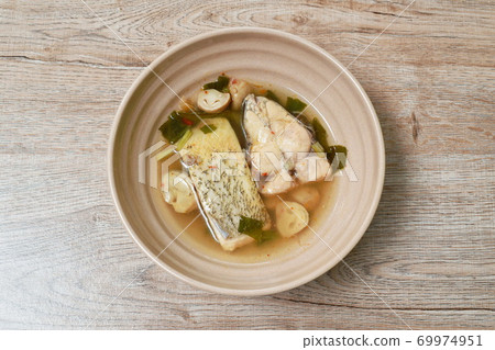 spicy slice pomfret or butter fish and straw mushroom in Tom Yum soup on bowl spicy slice pomfret or butter fish and straw mushroom in Tom Yum soup on bowl 69974951