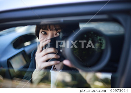 Woman taking pictures from inside the car 69975024