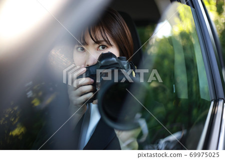 Woman taking pictures from inside the car 69975025
