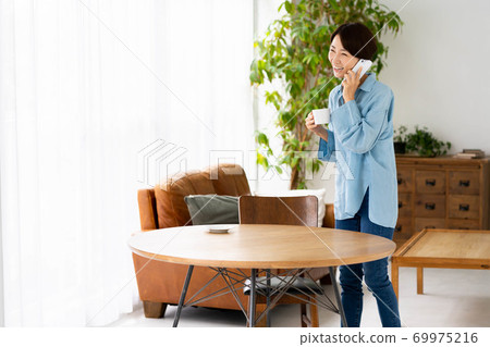 Female living room smartphone talking smile Female living room smartphone talking smile 69975216
