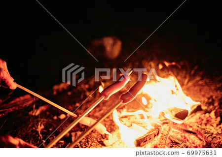 Frying sausages on fire 69975631