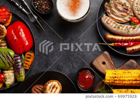 Grilled sausages and vegetables with spices and herbs 69975928