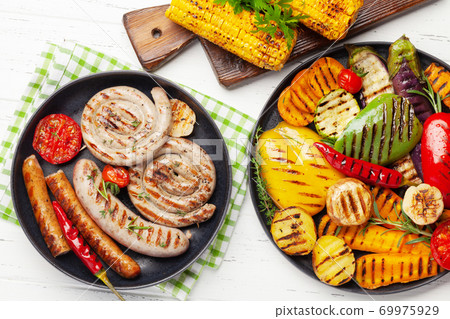 Grilled sausages and vegetables with spices and herbs 69975929