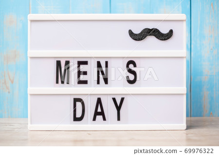 Men day text with mustache on lightbox. International Men day and Father day concept Men day text with mustache on lightbox. International Men day and Father day concept 69976322